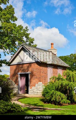 Bezauberndes Gebäude aus rotem Backstein mit Schieferdach und grüner Umgebung Stockfoto