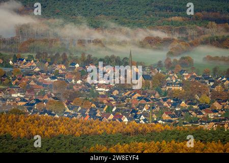 Aus der Vogelperspektive, Nebel über dem Dorf Hullern mit St. Andreas-Kirche, umgeben von herbstlichen Laubbäumen, Hullern, Haltern am See, Ruhrgebiet, Müns Stockfoto