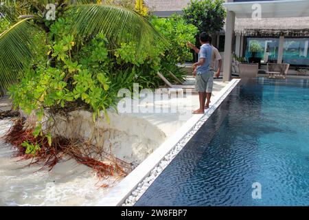 Malediven - 22. September 2013 : Gruppe einheimischer Arbeiter, die vor der Erosion am Meer unter einem Pool des Resorts steht Stockfoto