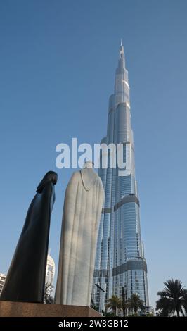 Die Skulptur von Araber und Araberin und der prächtige Wolkenkratzer Burj Khalifa in Dubai, VAE Stockfoto