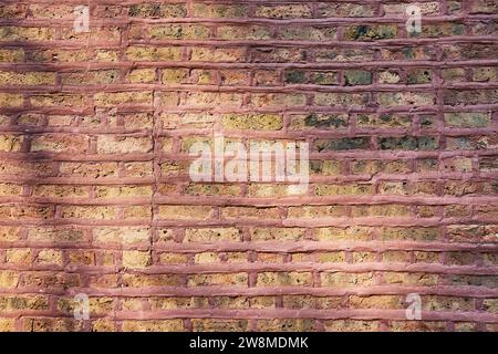 Braune Ziegelwand mit rotem Fugenmörtel, strukturierter Hintergrund Stockfoto