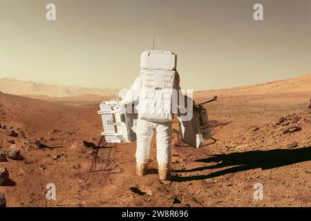Der Raumfahrer Astronaut in Einem Raumfahrtanzug mit Ausrüstung geht durch die Wüste mit Steinen und Bergen auf dem Roten Planeten Mars. Kolonization New Planet, C Stockfoto