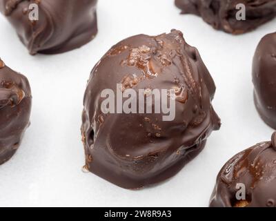 Eine fesselnde Nahaufnahme von handgefertigten schwedischen Lebkuchenbonbons, verziert mit dunkler Schokolade und bestreut mit Meersalzflocken, wunderschön Presente Stockfoto