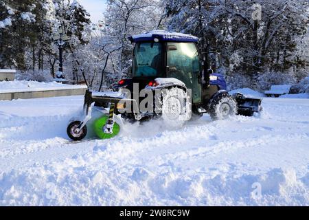 Reinigung der Straßen im Winter. Ein Traktor entfernt im Winter Neuschnee von schönen, verschneiten Straßen. Dnipro, Ukraine Stockfoto