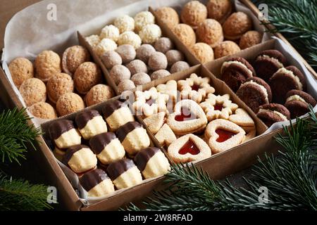 Variationen hausgemachter Weihnachtskekse in einer Geschenkbox auf einem Tisch Stockfoto