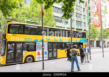 Sydney Australia B Line gelber Doppeldeckerbus an einer Haltestelle in der York Street Sydney, NSW, Australien, mit weihnachtsbannern im Flug Stockfoto