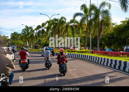 Asphaltstraßen und Verkehr mit Autos und Motorrädern auf der Insel Bali. Ein gemütlicher Weg durch asiatische Dörfer. Bali, Indonesien - 11.30.2022 Stockfoto