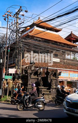 Asphaltstraßen und Verkehr mit Autos und Motorrädern auf der Insel Bali. Ein gemütlicher Weg durch asiatische Dörfer. Bali, Indonesien - 11.30.2022 Stockfoto