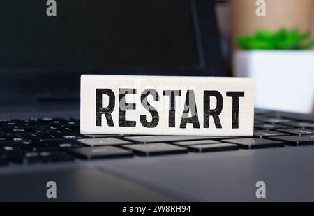 Symbol für Neustart und Start. Das Konzeptwort Restart auf Holzwürfeln. Schöner orangefarbener Tisch, orangefarbener Hintergrund, Kopierbereich. Neustart und Start des Unternehmens Stockfoto