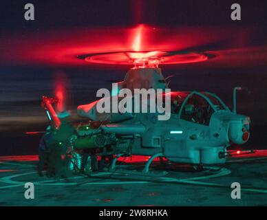 US-Seeleute, die dem amphibischen Dock-Landungsschiff USS Harpers Ferry (LSD 49) zugewiesen sind, tanken ein Marine Corps AH-1Z Viper, das der mittleren Tiltrotor Squadron (VMM) 165 (verstärkt), 15. Marine Expeditionary Unit, an Bord der Harpers Ferry im Pazifischen Ozean zugewiesen wurde, am 10. Dezember 2023. Die 15. MEU ist derzeit an Bord der Boxer Amphibious Ready Group, die integrierte Trainings- und Routineoperationen in der 3. US-Flotte durchführt. (Foto des U.S. Marine Corps von Lance CPL. Peyton Kahle) Stockfoto