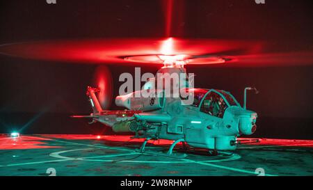 Ein U.S. Marine Corps AH-1Z Viper, das der mittleren Tiltrotor Squadron (VMM) 165 (verstärkt), 15. Marine Expeditionary Unit, zugeteilt ist, bereitet sich auf den Start vor, nachdem sie am 10. Dezember 2023 an Bord des amphibischen Dock-Landungsschiffs USS Harpers Ferry (LSD 49) im Pazifischen Ozean getankt wurde. Die 15. MEU ist derzeit an Bord der Boxer Amphibious Ready Group, die integrierte Trainings- und Routineoperationen in der 3. US-Flotte durchführt. (Foto des U.S. Marine Corps von Lance CPL. Peyton Kahle) Stockfoto