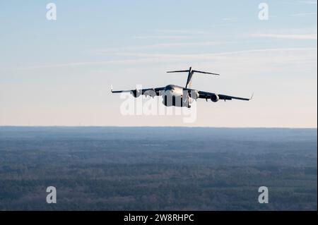 Ein C-17 Globemaster III, der dem 437. Airlift-Flügel zugewiesen ist, fliegt über einer Landezone während des Flugtrainings über North Carolina am 14. Dezember 2023. Der 437th Airlift Wing führte einen Kompetenzsprung mit der 82nd Airborne Division durch, um die Servicefreiheit zu verbessern, die erforderlich ist, um die Missionsqualität aufrecht zu erhalten. (Foto der U.S. Air Force von Staff Sgt. Emily Farnsworth) Stockfoto