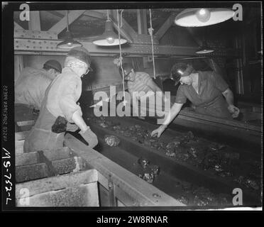 Frauen pflücken Fremdstoffe aus Kohle, während sie auf dem Förderband durch Tipple (3904009282) transportiert wird. Stockfoto