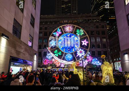 New York, USA, 20. Dezember 2023. Die Besucher beobachten eine spektakuläre Lichtershow über der Saks Fifth Avenue in New York City, Rockefeller Center A Stockfoto