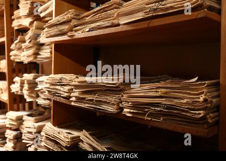 Sammlung alter Zeitungen auf Regalen in der Bibliothek Stockfoto