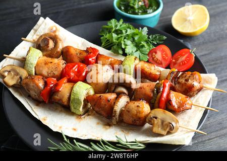 Leckere Shish Kebabs mit Gemüse auf dem Tisch, Nahaufnahme Stockfoto