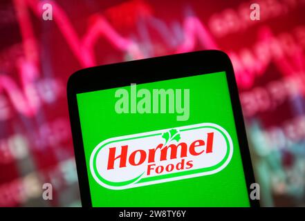 Kiew, Ukraine. Dezember 2023. In dieser Fotoabbildung ist das Logo der Hormel Foods Corporation auf einem Smartphone und einer Börsengrafik auf einem pc-Bildschirm zu sehen. Quelle: SOPA Images Limited/Alamy Live News Stockfoto