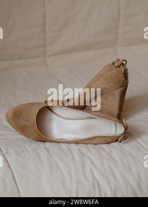 Vertikale Seitenansicht Nahaufnahme der beigefarbenen Hochplateau-Damenschuhe aus echtem Leder (Wildleder). Auf der Rückseite mit Spitzenschleifen verziert. Feinkost Stockfoto