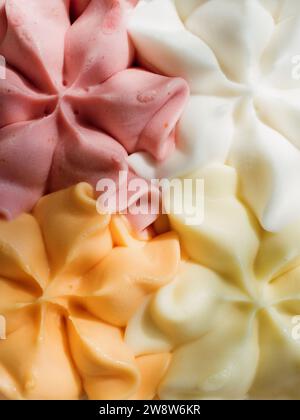 Eine vertikal ausgerichtete Nahaufnahme, die ein Eis in gedämpften Rosa-, Orange-, Gelb- und Weißtönen einfängt. Stockfoto