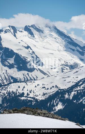 Vom Whistler Mountain aus bietet sich ein atemberaubender Blick auf die riesigen, schneebedeckten Gipfel der Kanadischen Rocky Mountains vor einem strahlend blauen Himmel. Stockfoto