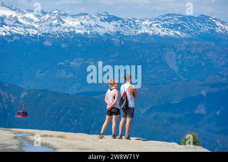 Ein Paar genießt die atemberaubende Aussicht vom Gipfel des Whistler Mountain, einem Juwel in den Kanadischen Rocky Mountains. Stockfoto