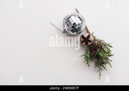 Hintergrund zum Neujahr. Goldene Tannenzapfen, Tannenzweig, Weihnachtskugel auf weißem Hintergrund. Draufsicht, Platz für Text. Stockfoto