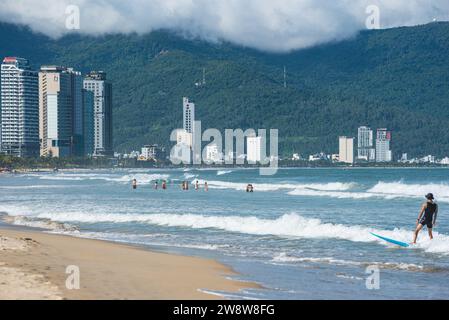 Da Nang, Vietnam - 4. Oktober 2023: Strand mit Schwimmern und Reihe moderner Hotels in der Ferne. Stockfoto