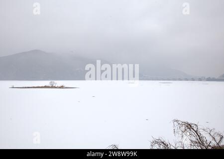 Namyangju City, Südkorea – 15. Februar 2020: Bedeckter Himmel ragt über der gefrorenen Weite des Paldang Lake, der von schneebedeckten Inseln und mir verstreut ist Stockfoto