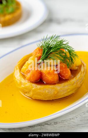 Artischocken mit Olivenöl, Karotten und Kartoffeln auf einer weißen Porzellanplatte Stockfoto
