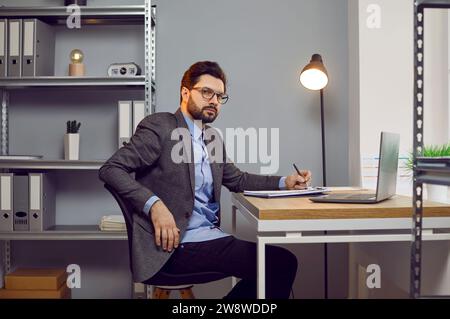 Porträt eines seriösen, selbstbewussten Geschäftsmannes, der in einem modernen Büro arbeitet Stockfoto