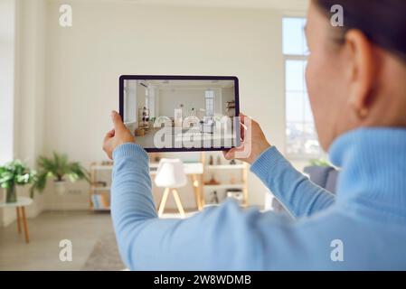 Immobilienmakler nutzen ein digitales Tablet, um eine Foto- oder Videotour über neue Wohnungen zum Verkauf zu machen Stockfoto