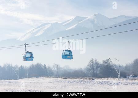 Bansko, Bulgarien - 20. Dezember 2023: Bulgarisches Winterskigebiet Panorama mit Gondelbahn, Blick auf die Berggipfel Pirins Stockfoto