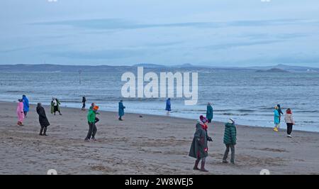 Portobello, Edinburgh, Schottland, Großbritannien. 22. Dezember 2023. Wintersonnenwende, „Achtsamkeit Bewegung Silent Disco Body Centred Coaching“ mit „Move to Feel“ neben dem Firth of Forth, „eine kreative achtsame Bewegungspraxis, ein unterhaltsames therapeutisches Ereignis, bei dem die Intelligenz des Körpers durch Fühlen, Fühlen, Erkunden, Bewegen, Gestalten und Verbinden zusammengeführt wird“. Quelle: Archwhite/Alamy Live News. Stockfoto