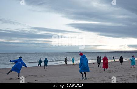 Portobello, Edinburgh, Schottland, Großbritannien. 22. Dezember 2023. Wintersonnenwende, „Achtsamkeit Bewegung Silent Disco Body Centred Coaching“ mit „Move to Feel“ neben dem Firth of Forth, „eine kreative achtsame Bewegungspraxis, ein unterhaltsames therapeutisches Ereignis, bei dem die Intelligenz des Körpers durch Fühlen, Fühlen, Erkunden, Bewegen, Gestalten und Verbinden zusammengeführt wird“. Quelle: Archwhite/Alamy Live News. Stockfoto