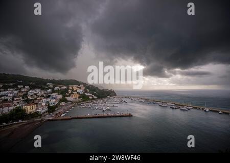 Luftaufnahme des Yachthafens und der Häuser der Stadt Agropoli, nachts beleuchtet, Sturmwolken in der Ferne. Stockfoto