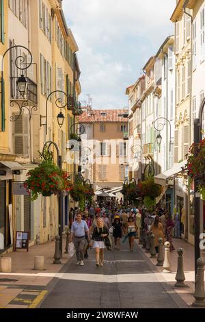 Typische Straßen-/Straßenszene in Antibes in der Rue Georges Clemenceau, 06600, Frankreich. Shopper stöbern in den Geschäften der historischen Altstadt. (135) Stockfoto