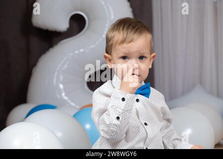 Ein kleiner zweijähriger Junge zeigt seine Nase mit dem Finger. Fähigkeiten für 2-Jährige. Stockfoto