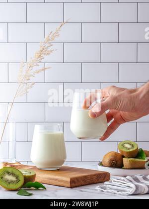 Die Hand eines Mannes hält ein Glas selbstgemachten Joghurt Stockfoto