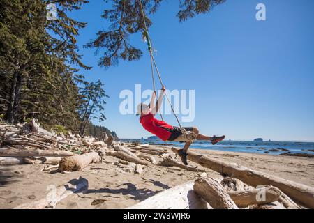 Ein Mann schwingt auf Treibholz und schwingt entlang des Pacific Northwest Trail Stockfoto