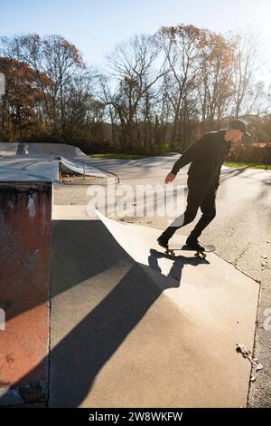 Solo-Mann-Skateboarden auf einer Skatepark-Rampe im Herbst Stockfoto