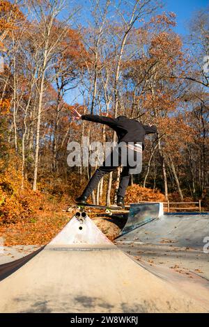 Solo-Mann-Skateboarden auf einer Skatepark-Rampe im Herbst Stockfoto