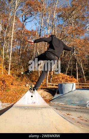 Solo-Mann-Skateboarden auf einer Skatepark-Rampe im Herbst Stockfoto