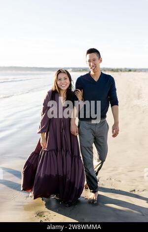 Asiatisches Paar spaziert am Strand bei Sonnenuntergang in San Diego entlang Stockfoto