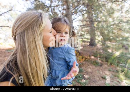 Mom küsst Mädchen auf die Wange im Park Stockfoto