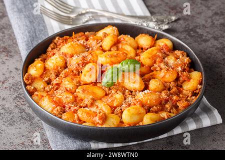 Hausgemachte köstliche Gnocchi Bolognese Nahaufnahme auf dem Teller auf dem Tisch. Horizontal Stockfoto