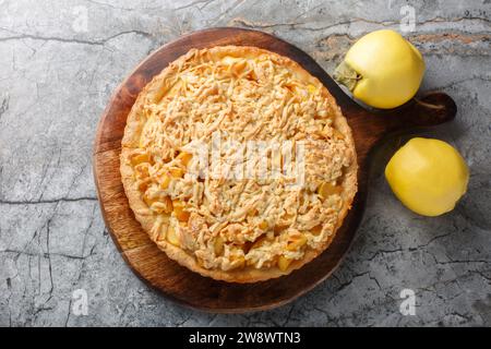 Köstlicher herbstlicher Quittenkuchen mit Streusel-Closeup auf dem Holzbrett auf dem Tisch. Horizontale Draufsicht von oben Stockfoto