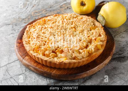 Crumble Tarte köstliche Kombination aus süßer, reichhaltiger Quitte mit Streusel Closeup auf dem Holzbrett auf dem Tisch. Horizontal Stockfoto