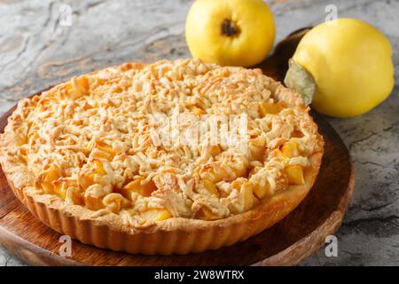 Köstlicher herbstlicher Quittenkuchen mit Streusel-Closeup auf dem Holzbrett auf dem Tisch. Horizontal Stockfoto