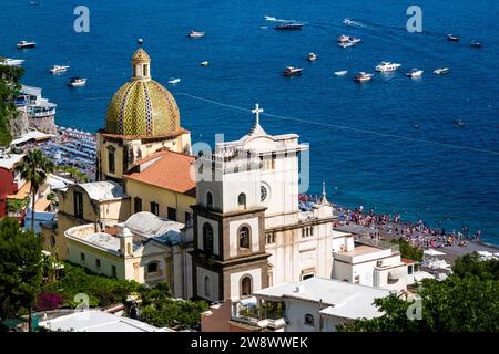 Blick aus der Vogelperspektive auf die Häuser und die Kirche Santa Maria Assunta von Positano an der Amalfiküste, auf einem Hügel mit Blick auf das Mittelmeer. Stockfoto