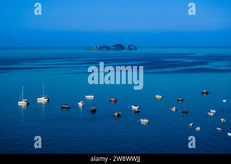 Segel- und Ausflugsboote vor der Küste der Stadt Positano an der Amalfiküste, der Insel Il Gallo Lungo in der Ferne. Stockfoto